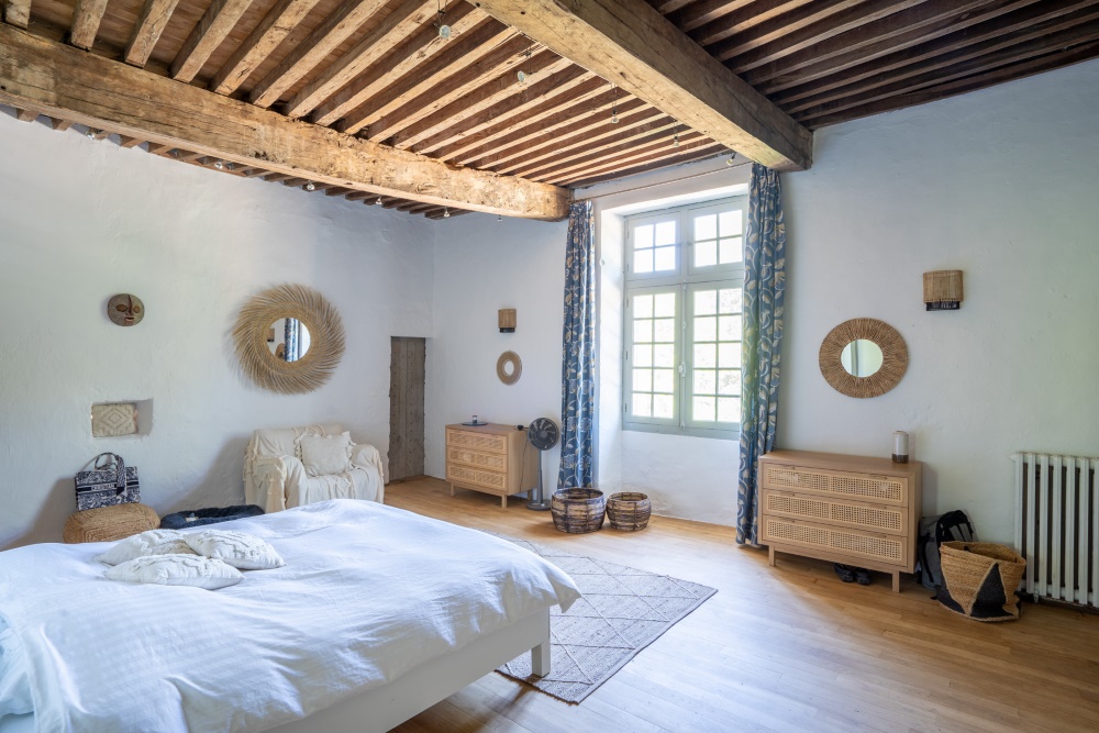 Bedroom 2, 6.8x5.3m, with chestnut flooring, wall of bookshelves, with plaster mouldings above fireplace. 