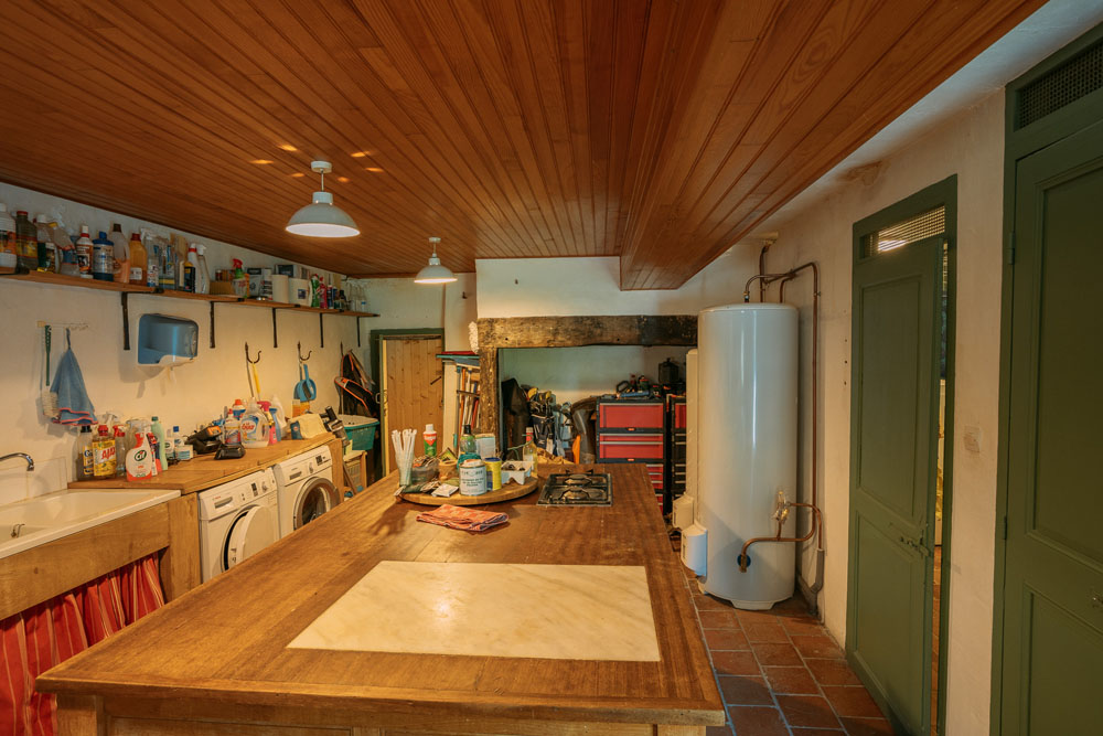 Utility room, 3.7x6.5m, with central island, double sinks and connections for laundry appliances.